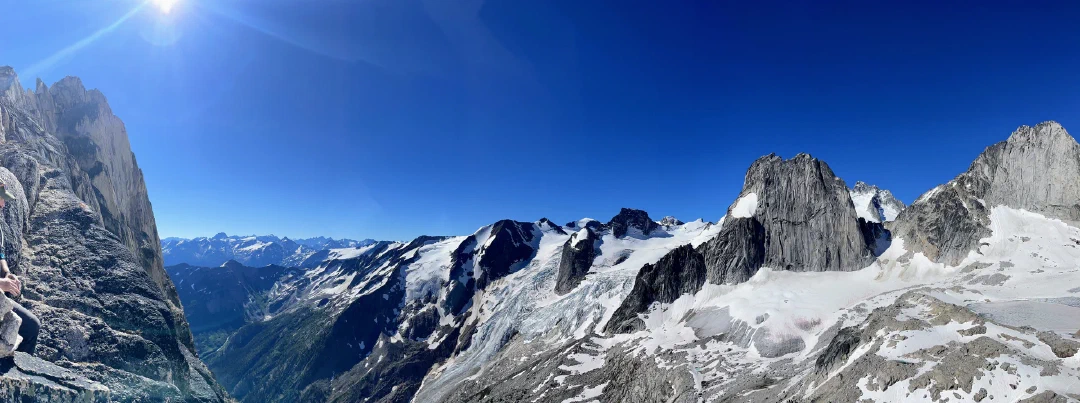 Panorama from Eastpost Spire overlooking Houndstooth icefall, Snowpatch Spire, distant Howser Spire, and Bugaboo Spire.