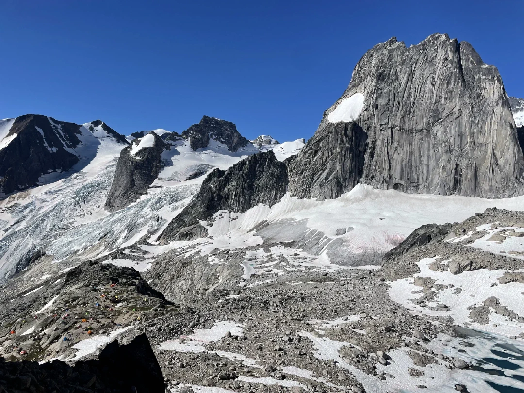 Snowpatch Spire, its namesake patch on the face, glaciers and tents of camp below