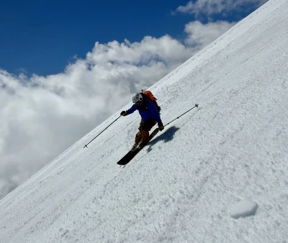 Skiing down a steep corn-snow face.