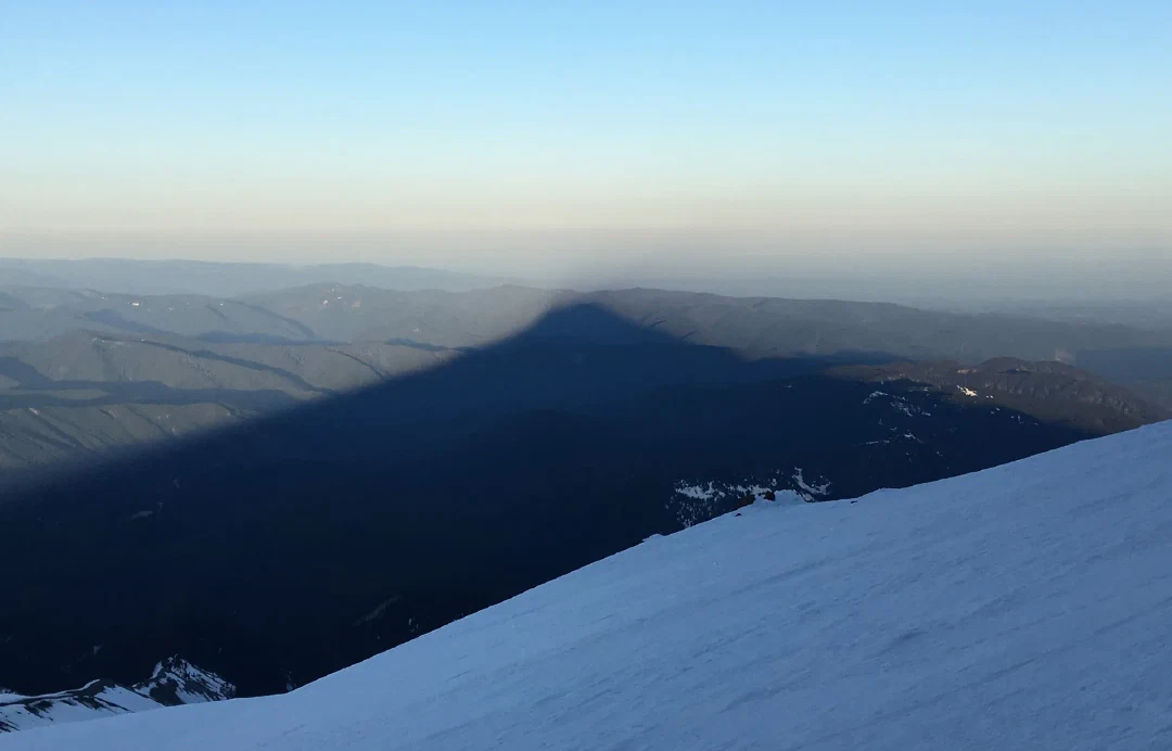 Mt Hood’s triangular shadow stretching across the foothills.