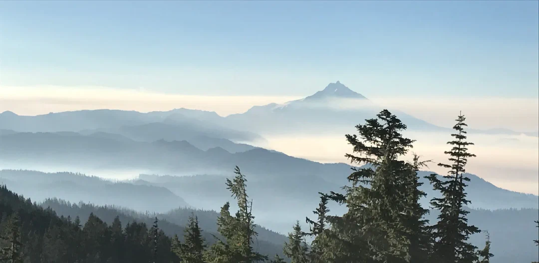 Mt Jefferson’s horn rising above layers of blue ridges and valley haze in early morning light