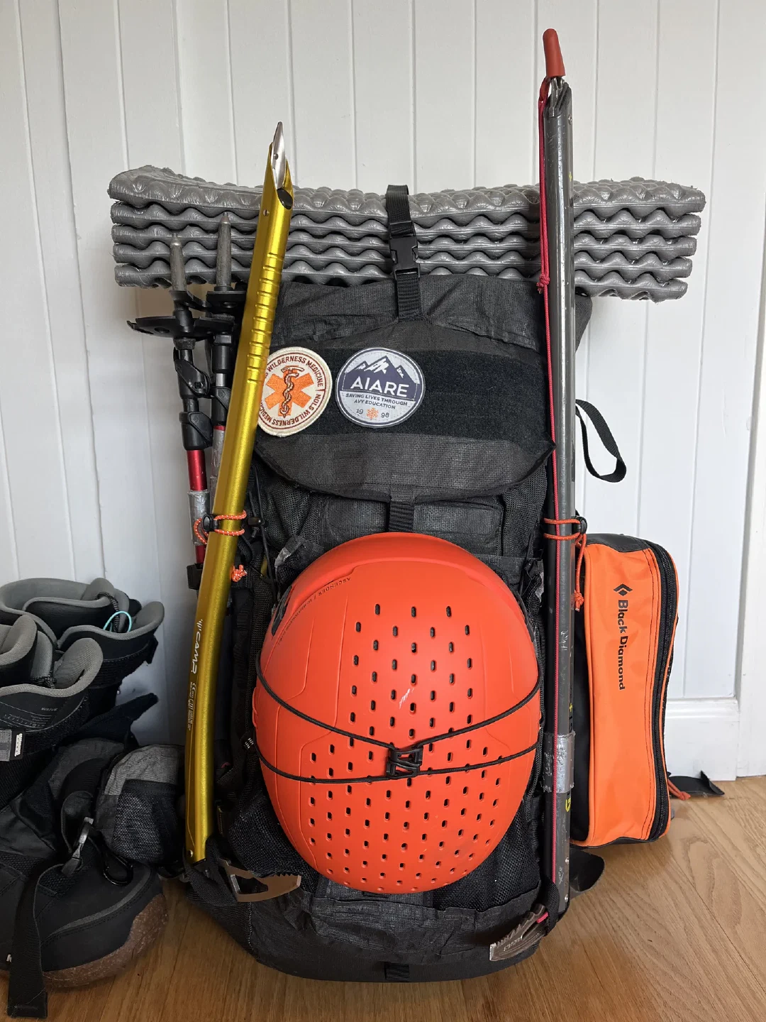 Kitted for the alpine: helmet bungeed, ice axes, poles, crampons, and foam pad up top.