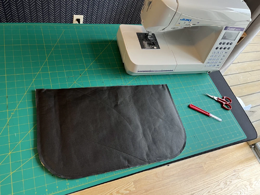 A black Ultra panel cut and ready beside the sewing machine