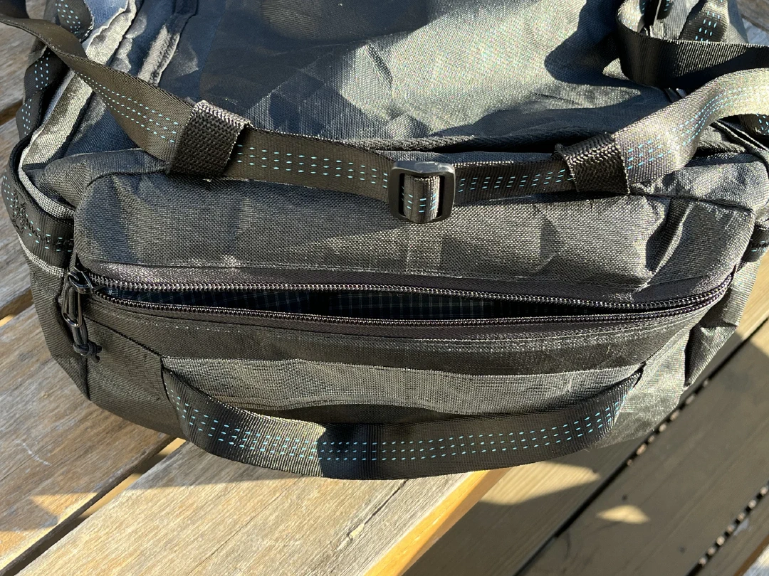The externally accessible end pocket zipped shut above the grab handle
