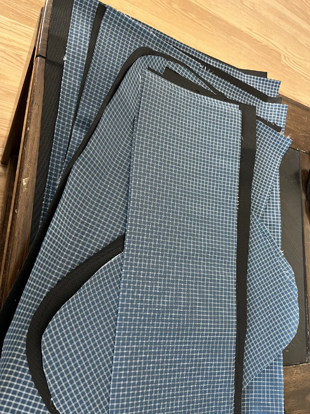 Blue gridstop liner panels cut and edge-bound in black, stacked on the floor