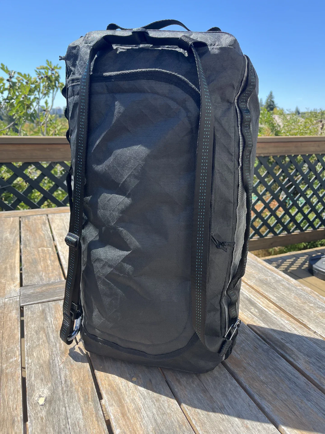 The duffle standing upright on one end, with carry strap carabinered for backpack carry.